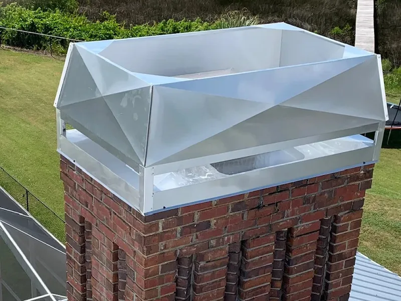 Galvanized steel chimney cap installed on brick chimney exterior in Florida