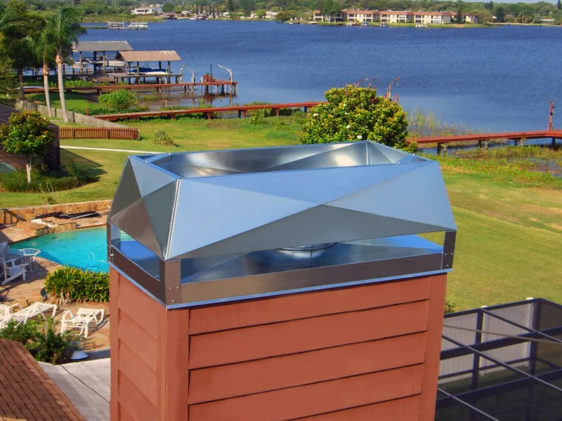 Stainless steel chimney cap installed on brick chimney overlooking waterfront property